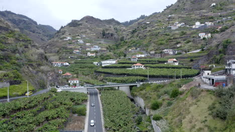 an aerial shot flying through a valley in madeira with the terraced fields for growing crops in ribeira brava in the village of tabua on the south coast of madeira island, portugal