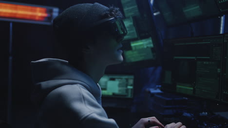 person wearing vr/ar headset interacting with multiple computer screens in a dark room
