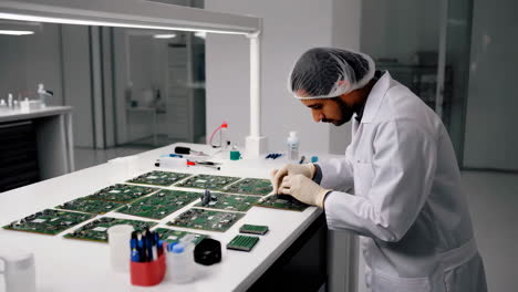 electronics technician working on circuit boards in a clean room
