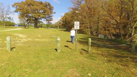 La-Mujer-Camina-Por-El-Parque-No-Hay-Autos-Más-Allá-De-Este-Punto-De-Señal-Y-Permanece-En-El-Sendero-Del-Parque