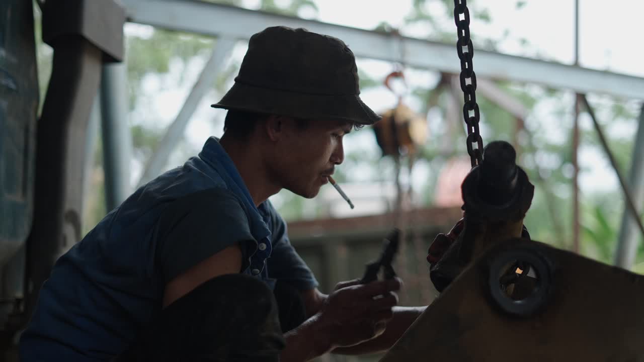 Worker repairing machinery in a factory