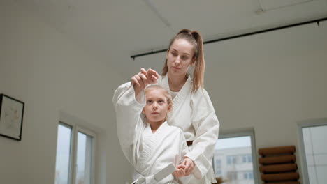 pupil and teacher in white kimono in martial arts class