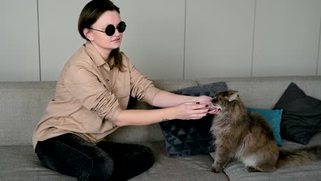 Mujer-Ciega-Con-Gafas-De-Sol-Sentada-En-Un-Sofá-En-Casa-Y-Acariciando-A-Su-Gato-1