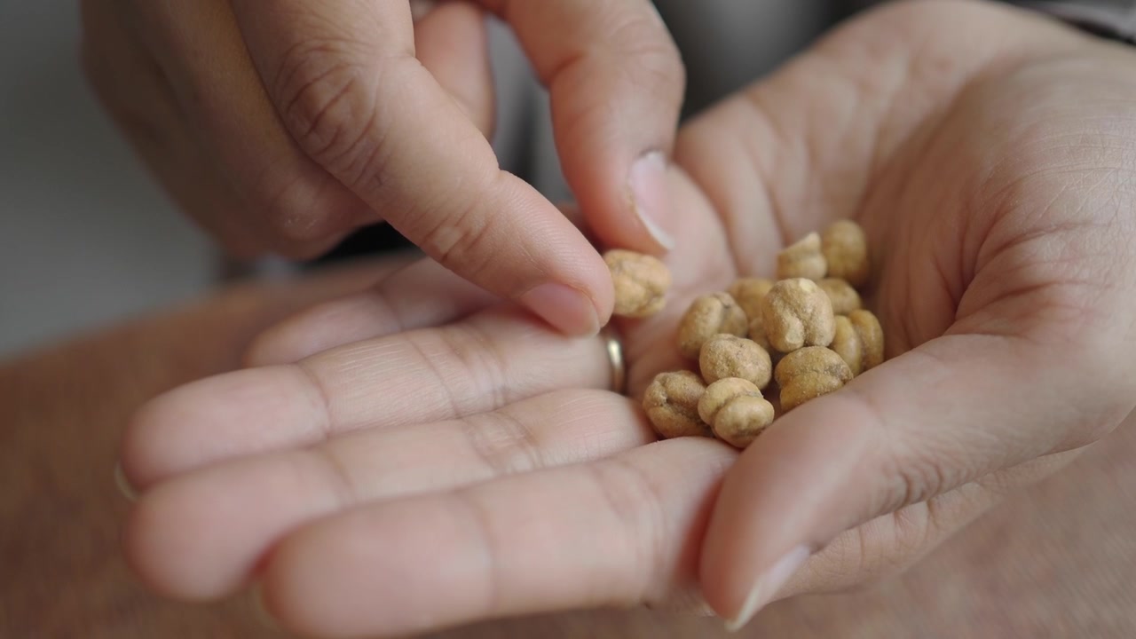 Primo piano di mani che mangiano ceci arrostiti salutari