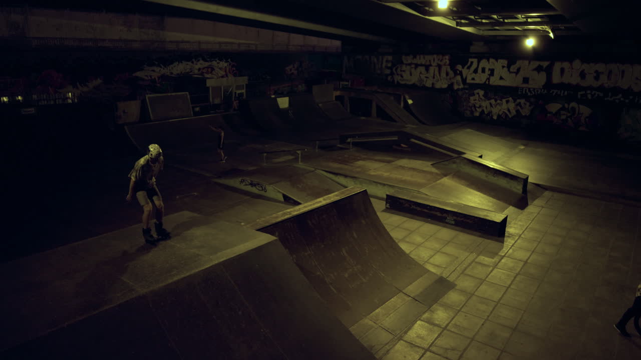 Sporty venner træner sammen i skatepark i fritiden om aftenen