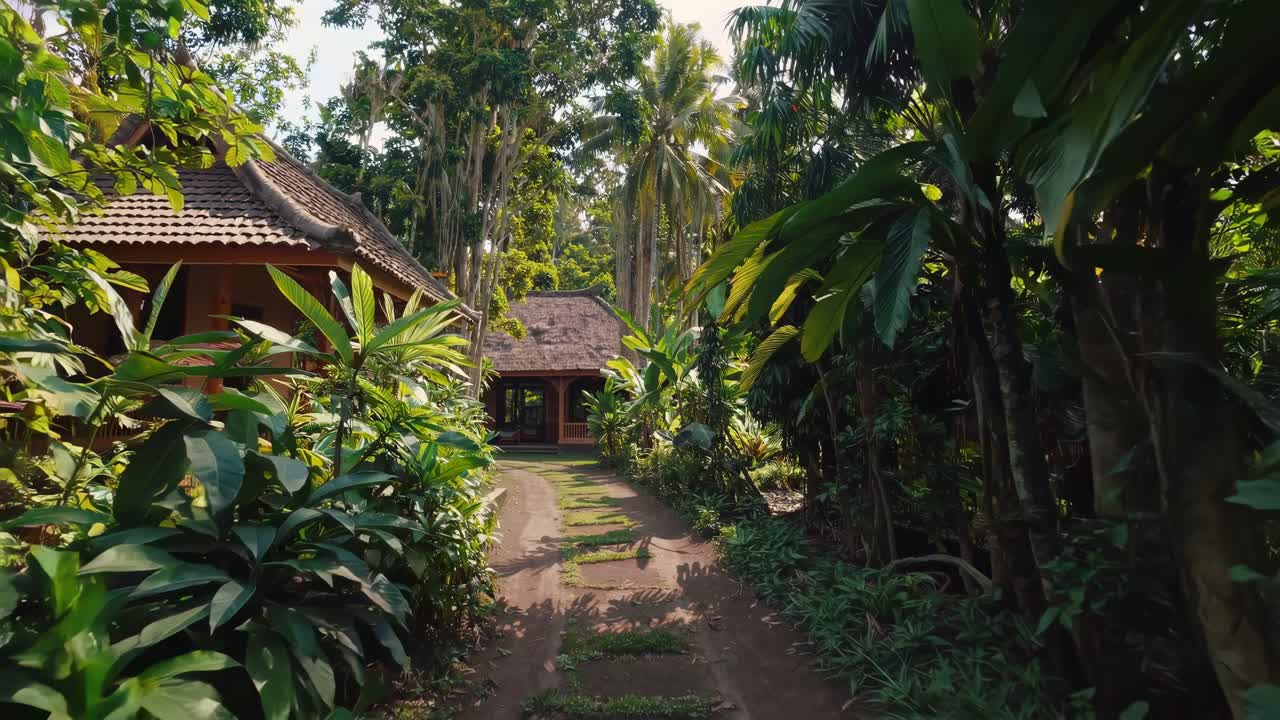 Wooden pathway winding through lush tropical greenery toward rustic traditional bungalow in Balinese landscape, revealing peaceful island setting
