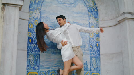 personas enamoradas abrazándose en la arquitectura de azulejos de cerca. hombre inclinando a la mujer