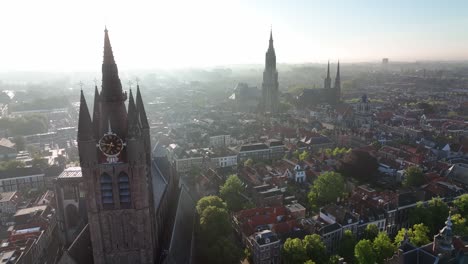 Cinematic zoom in of Nieuwe Kerk tower in Delft with cityscape in the background during clear morning light