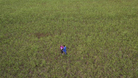 Young-couple-holding-hands-in-a-field