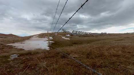 a liquor bottle litters the fenceline of this old west time lapse near the highway