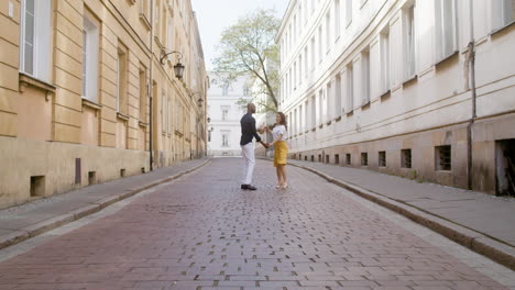 zoom avant sur un couple interracial heureux dansant la bachata dans la rue de la vieille ville