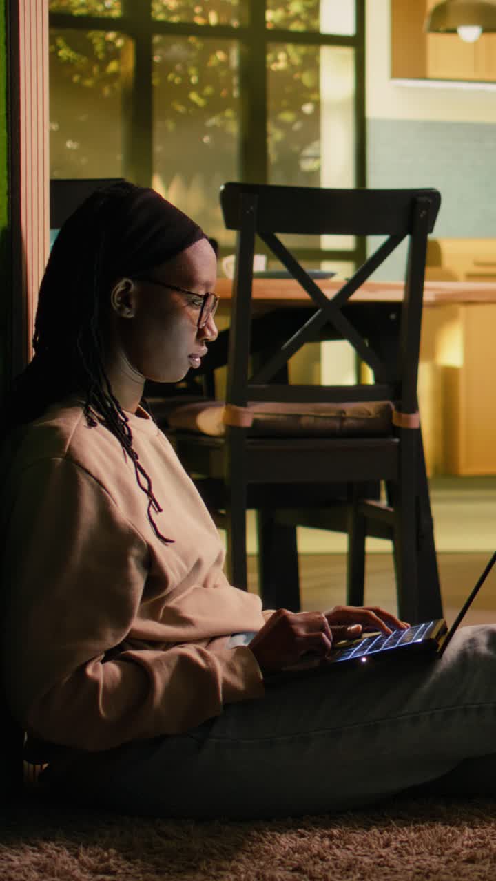 Vertical Video African American girl enjoying relaxation and browsing apps on laptop