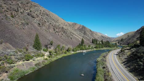 snake river idaho with two lane road on river bank and car driving by- aerial