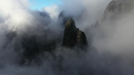 drone shot tilting upwards over the cloudy and sunny landscape of pico das torres in madeira