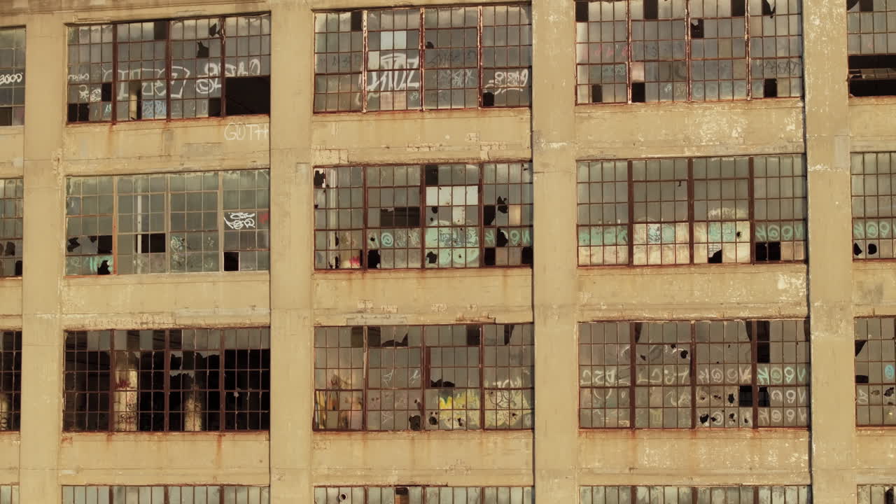 Aerial view of the exterior of an abandoned warehouse at sunset.