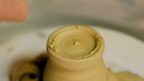 taza de tallado de alfarero profesional con herramienta especial en taller de cerámica