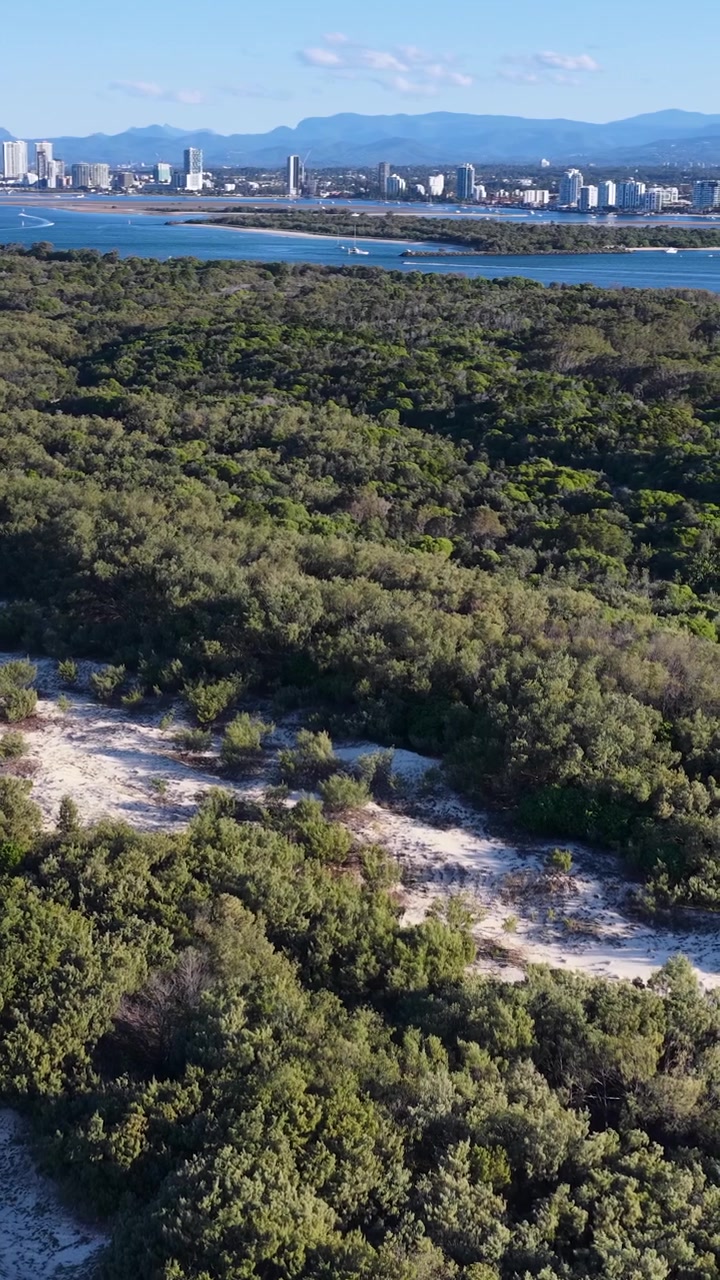 Vista aerea di dune di sabbia costiere e skyline cittadino distante