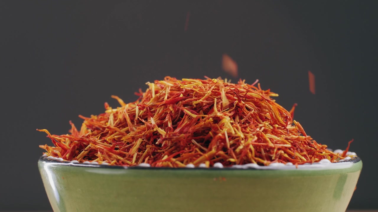 Saffron Threads Falling into a Green Bowl