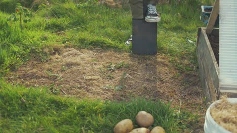 Joven-Cavando-Tierra-Vegetal-Para-Plantar-Papas-A-Mitad-De-Camino