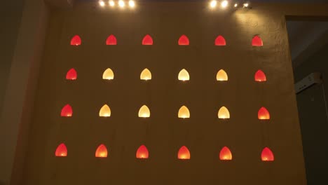 Small-alcove-windows-illuminated-with-yellow-and-red-lights-at-Buddhist-temple,-Thailand