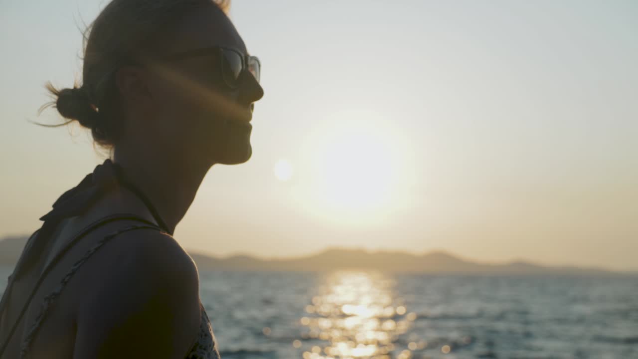 Woman enjoying sunset by the ocean