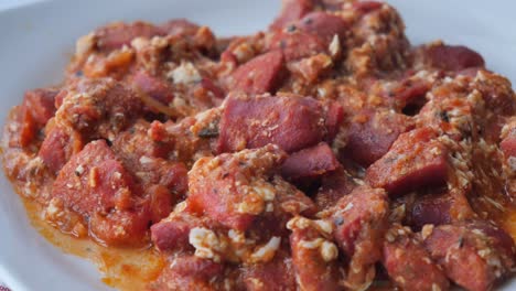 tomato scrambled eggs and sausage in a bowl