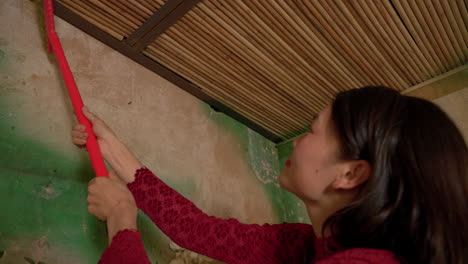 chinese new year celebration , slow motion of housewife woman in traditional clothing cleaning the house before the event celebration holiday