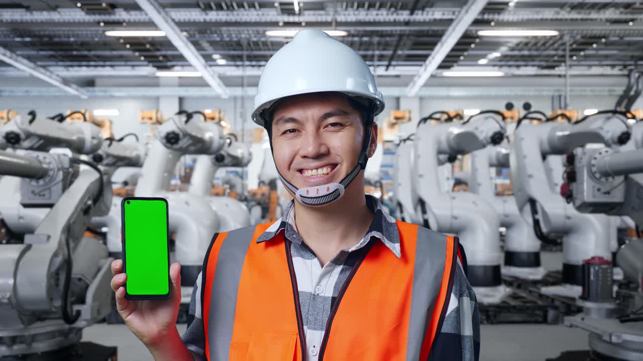 공장에서 녹색 화면 스마트폰을 가진 엔지니어