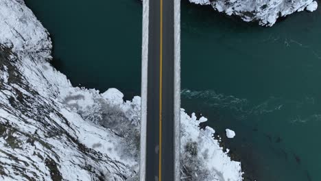 overhead aerial view of an empty bridge with snow covering the land