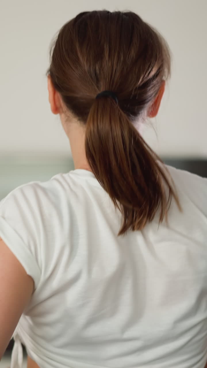 여성은 가정 체육관에서 포니테일로 머리카락을 습니다. 조을 준비합니다. 스포츠 을 입은 역동적인 운동 선수는 실내에서 트레드밀에서 달리는 짧은 머리를 준비합니다.