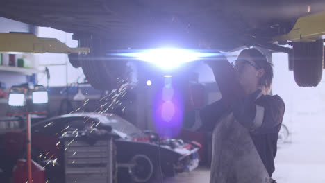 animation of light over caucasian female mechanic fixing car