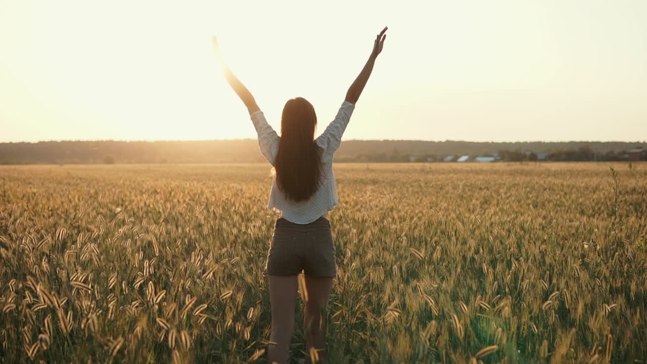 mujer disfrutando de la puesta de sol en un campo de trigo