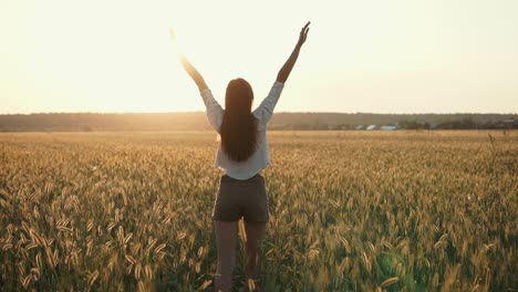 woman enjoying sunset in a wheat field