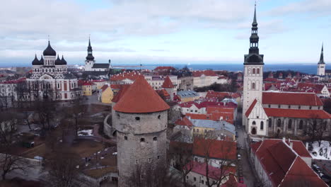 aerial descending shot of tallinn old town with churches and defensive wall