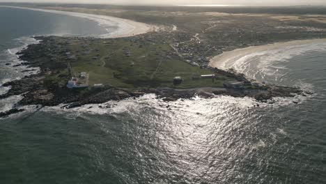 aerial drone view above beach and shore of cabo polonio uruguayan travel destination, sun reflected on calm blue waves