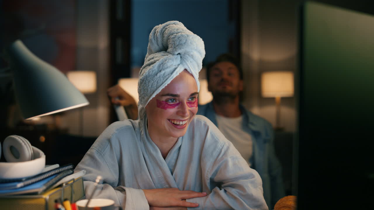 Bathrobe lady laughing workplace remotely closeup. Woman trying ignore husband