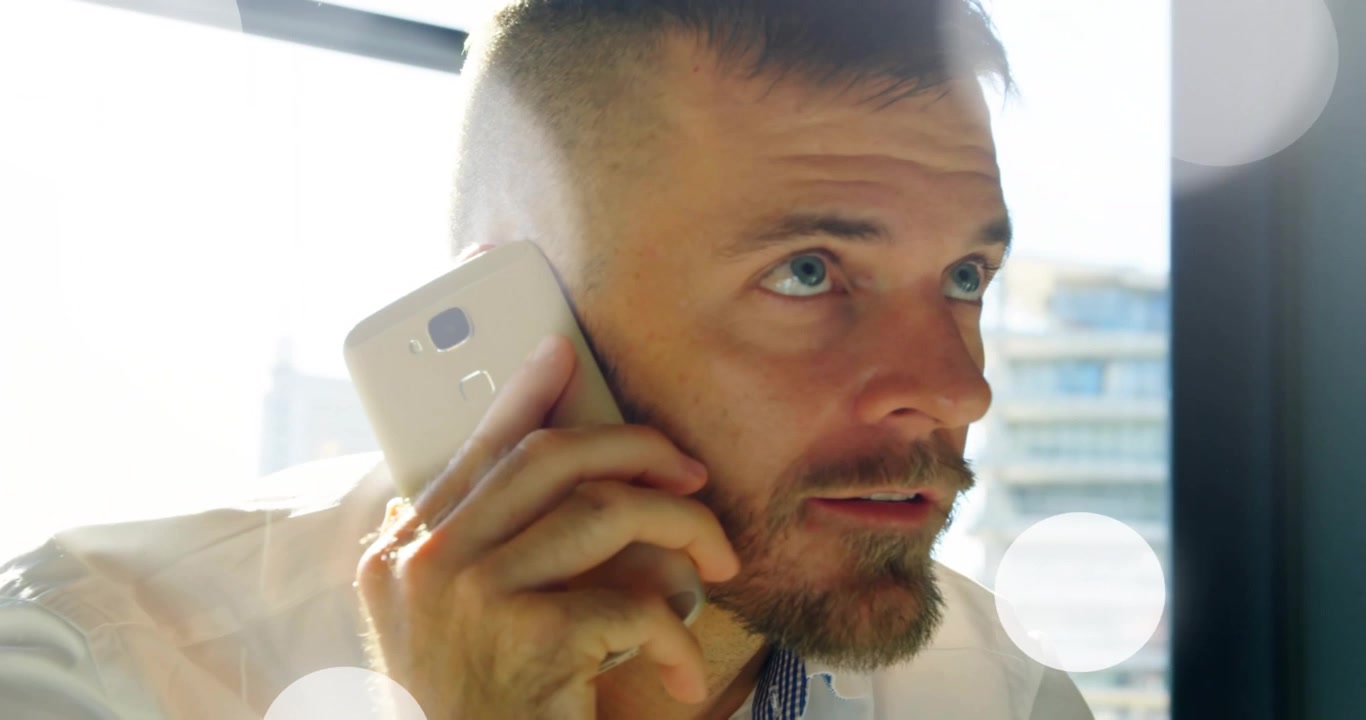 Exec holding gold smartphone, receiving client call, adjusting phone while waveform pulsing around