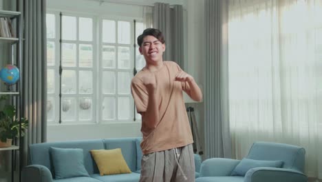 Asian Man Dancing While Shooting Video Content For Social Networks At Home