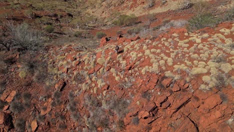 Aerial-top-down-shot-of-man-on-peak-of-desert-mountain-taking-pictures-with-mobile-phone-at-sunny-day