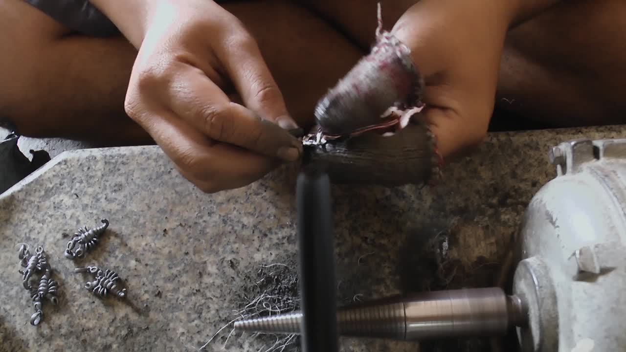 un artesano está pintando las baratijas con una máquina de manera tradicional