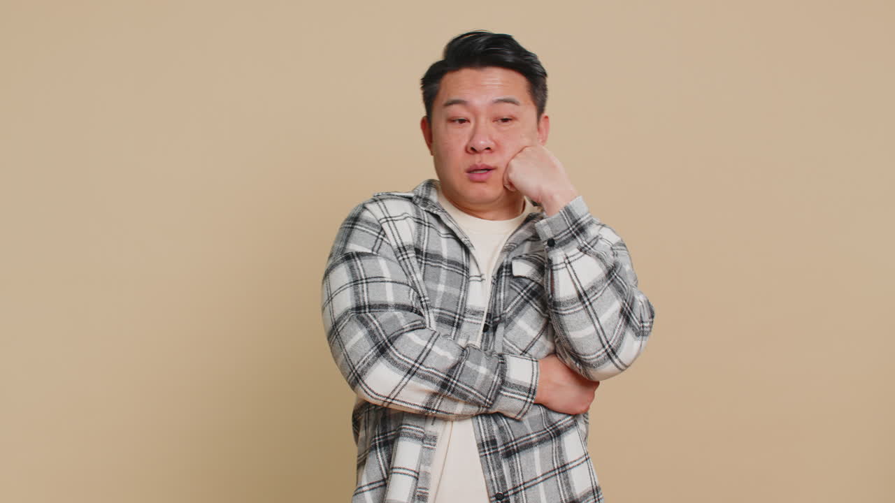 아시안 남자가 피곤하고 지루한 표정, 지루한 이야기에 지쳤고, 의사소통에 관심이 없다.