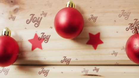 animation of joy text in repetition over christmas baubles