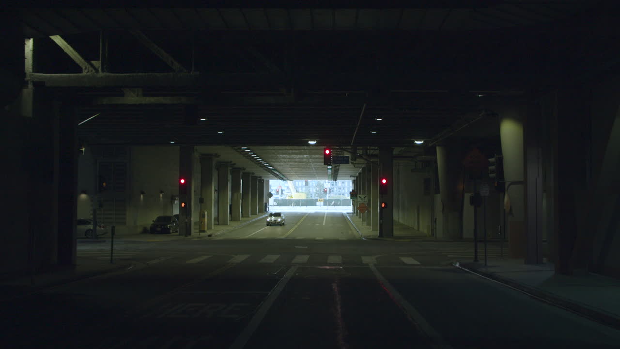 Car Driving Through a City Underpass with Traffic Lights