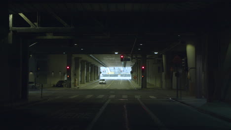 car driving through a city underpass with traffic lights