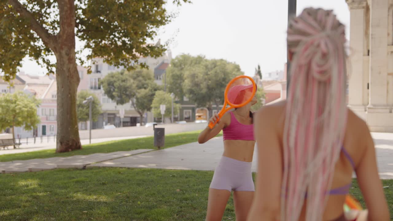 Two women playing tennis outdoors
