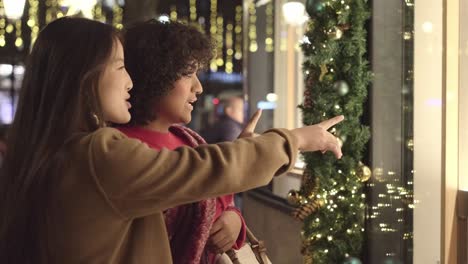 two women window shopping during christmas holidays