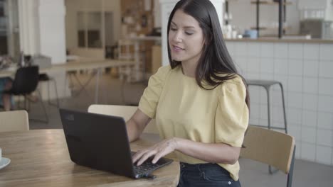 joven empresaria positiva usando laptop