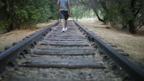 Slow-Motion-Shot-of-a-lonely-person-walking-on-abandoned-Train-Tracks