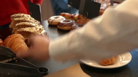 Waitress-serving-a-croissant-to-customer