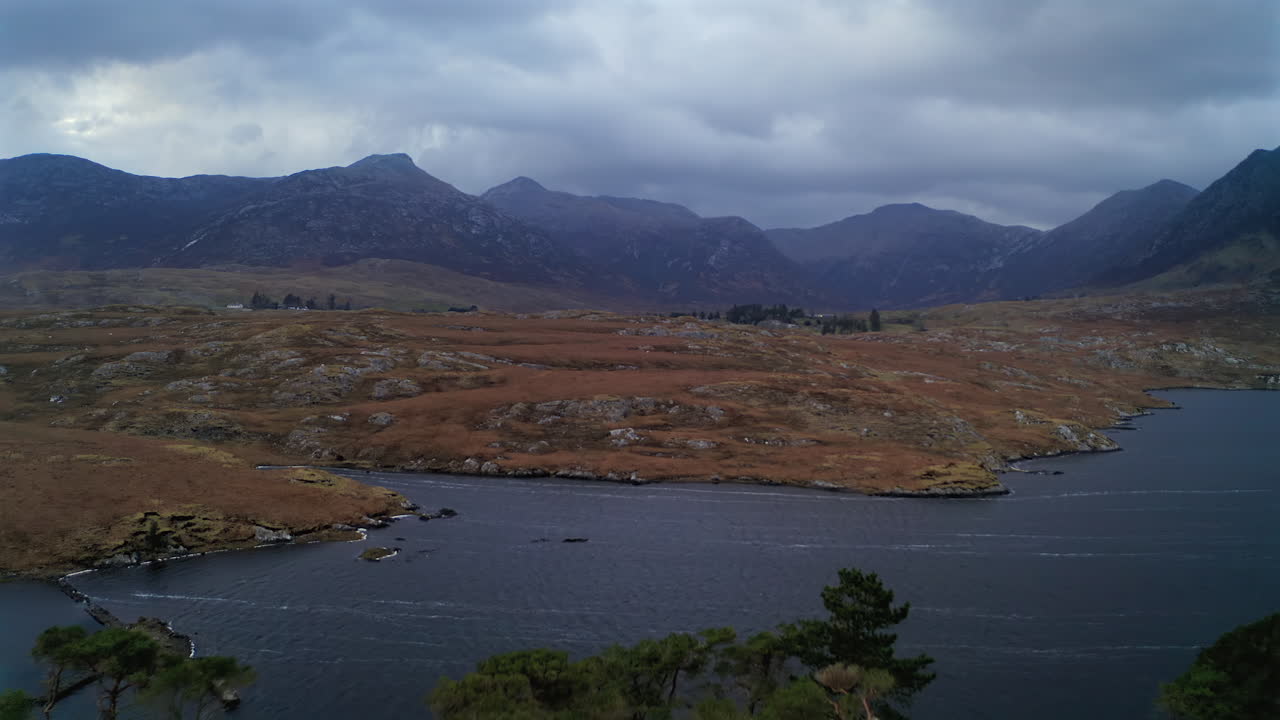 Aerial pullback and ascend over Pine Island, unveiling Connemara’s dramatic landscape under stormy blue light